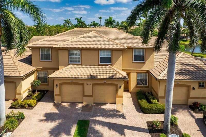 View of property featuring a tile roof, stucco siding, and decorative driveway