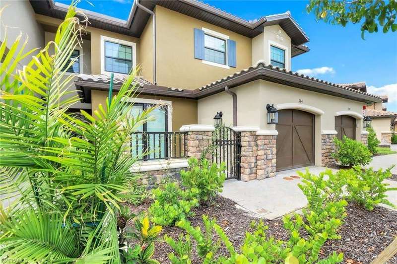 View of front facade with stucco siding, stone siding, and a garage