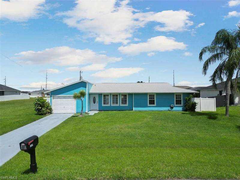 Ranch-style house with a garage and a front yard