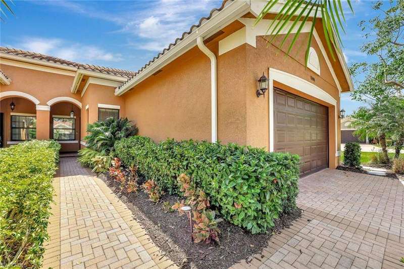 Welcoming paver walkway leads you through lush, manicured landscaping to the charming front entrance of this beautifully maintained home. The exterior features a warm, Mediterranean-inspired color palette, complemented by a tile roof and tasteful architec