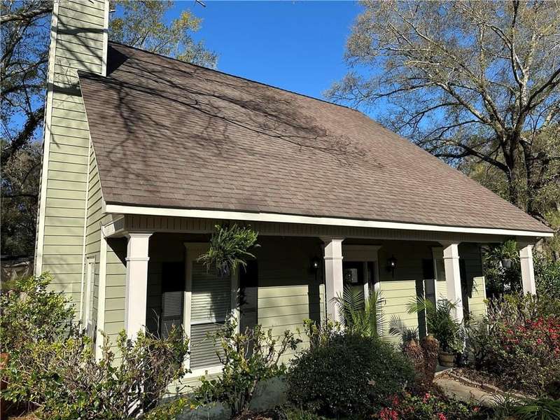 View of front facade with roof with shingles and a chimney