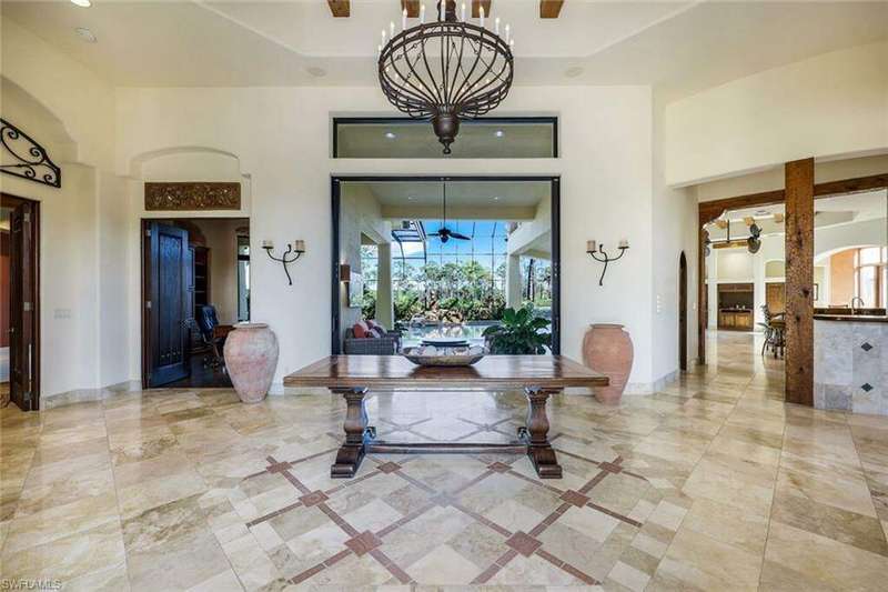 Foyer with a towering ceiling, an inviting chandelier, a healthy amount of sunlight, and sink