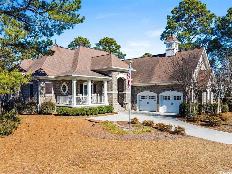 View of front of home with a garage and covered po
