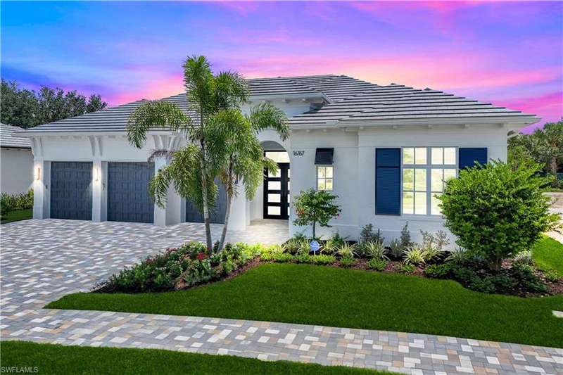 Contemporary house with a tile roof, decorative driveway, a yard, and stucco siding