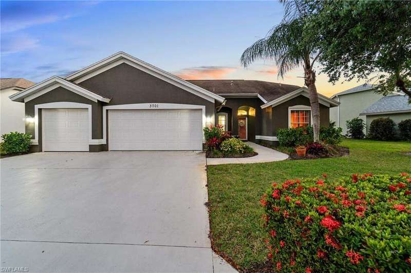 Single story home featuring stucco siding, an attached garage, driveway, and a lawn