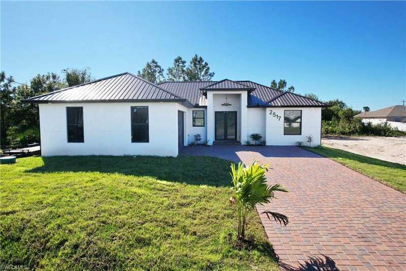 View of front facade with a garage and driveway pavers