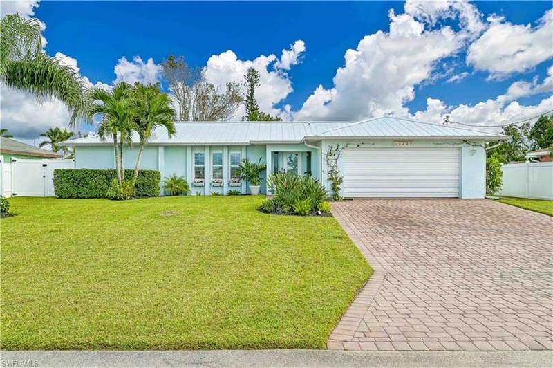 Front of home featuring metal roof, paved driveway and 2 car garage.