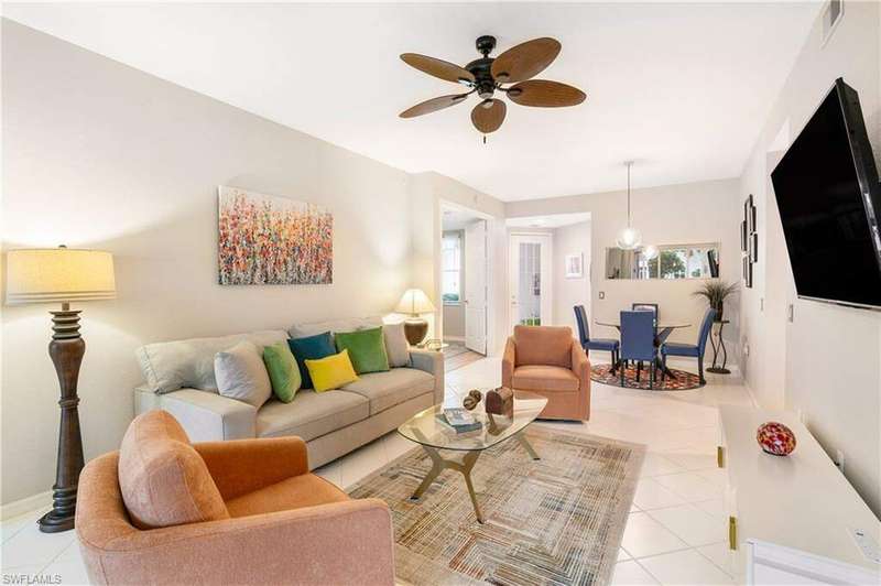 Living room featuring light tile patterned floors and ceiling fan