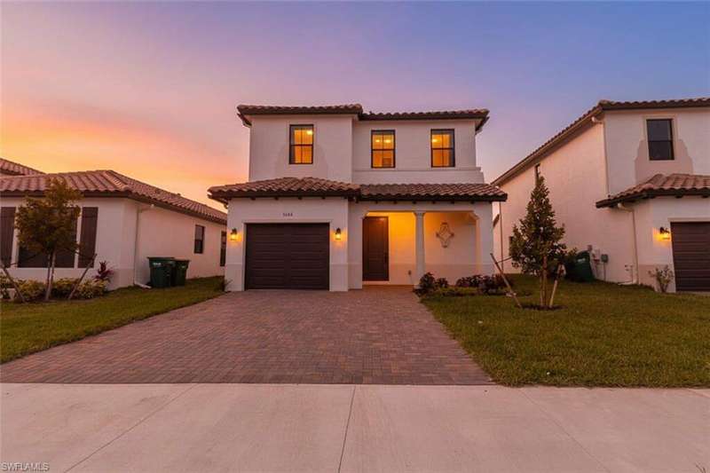 Mediterranean / spanish-style home with paved driveway, and a garage