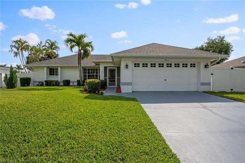 Single story home featuring a gate, concrete driveway, stucco siding, a front lawn, and a garage