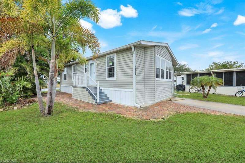 View of front facade with a front lawn and a sunroom