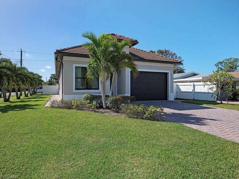 View of front of property with a garage and a front lawn