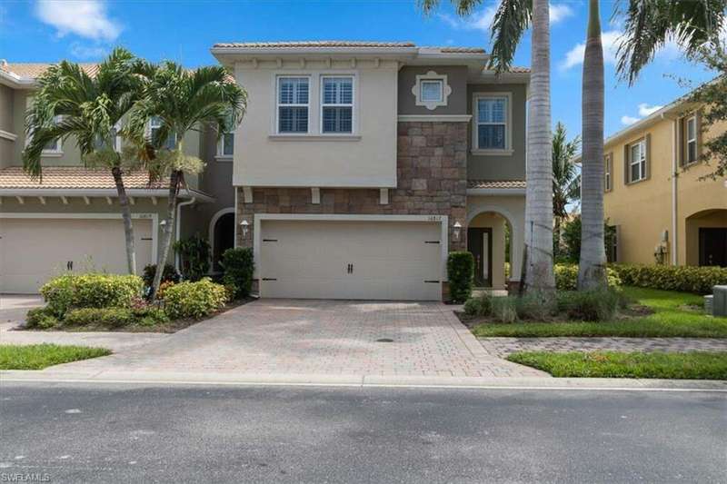 Mediterranean / Spanish-style end unit home featuring a garage