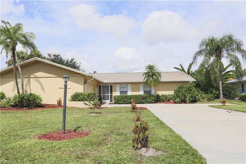 Ranch-style home featuring a front yard, concrete driveway, stucco siding, and a shingled roof