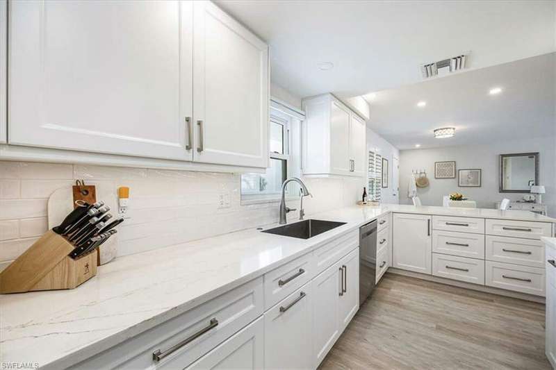 Kitchen with single bowl sink, white cabinetry, quartz countertops