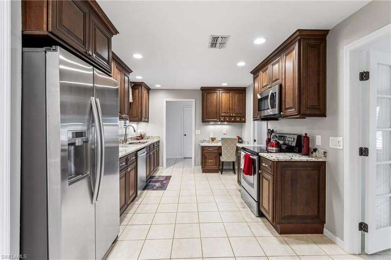 Kitchen featuring light tile patterned floors, visible vents, appliances with stainless steel finishes, and a sink