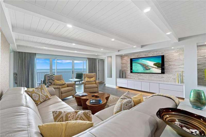 Living room with beamed ceiling, wood finished floors, and recessed lighting