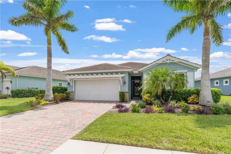 Single story home with an attached garage, decorative driveway, stucco siding, a tile roof, and a front lawn