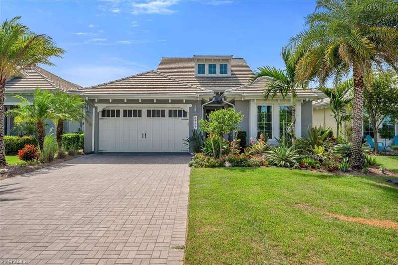 View of front facade featuring decorative driveway, a front yard, stucco siding, a garage, and a tile roof