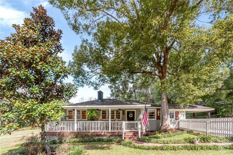 Single story home featuring covered porch, a chimney, and fence