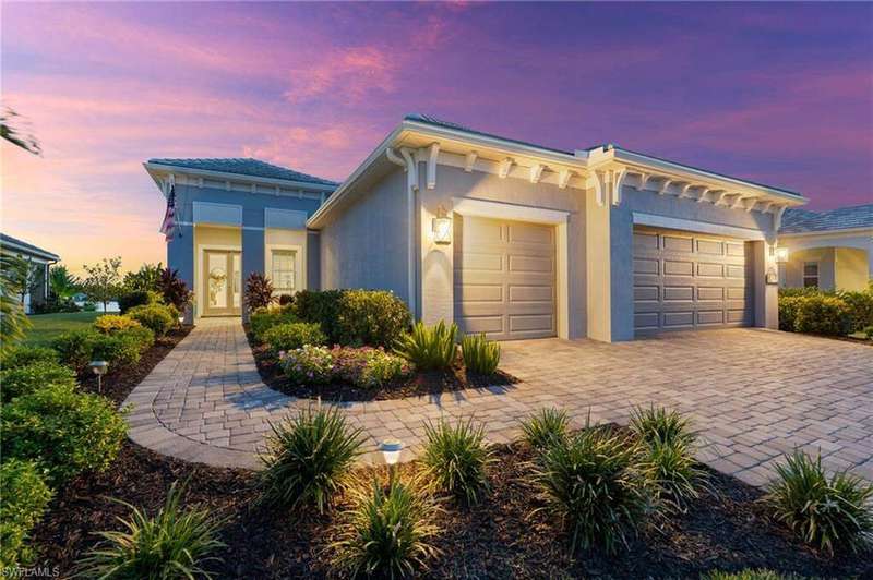 View of front of house with stucco siding, decorative driveway, and a garage