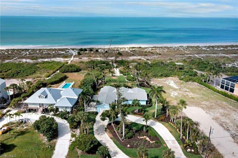 Birds eye view of property featuring a water view and a view of the beach