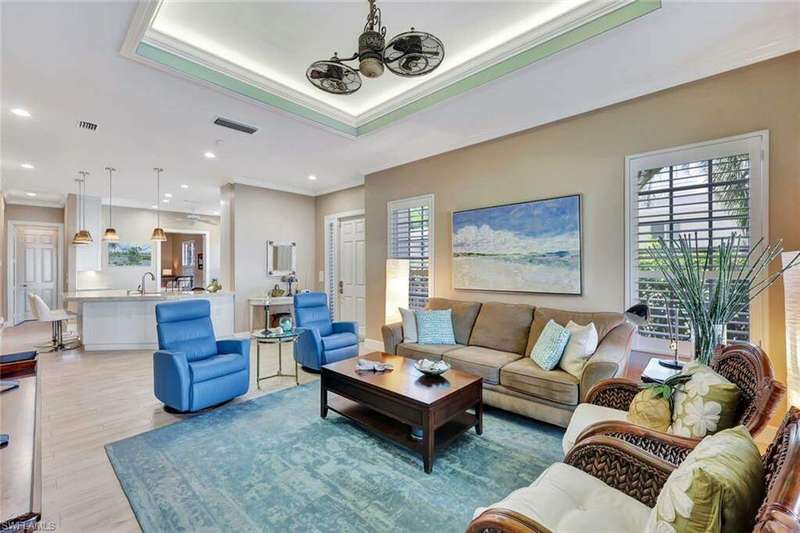 Great room with volume ceiling with tray, crown moldings and accent lighting. Plantation shutters. Opens screened lanai via sliding glass doors, dining room and reconfigured kitchen with Taj Mahal granite