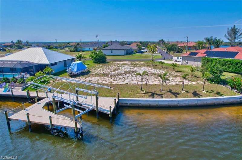 Dock with boat lift, a residential view, and a water view