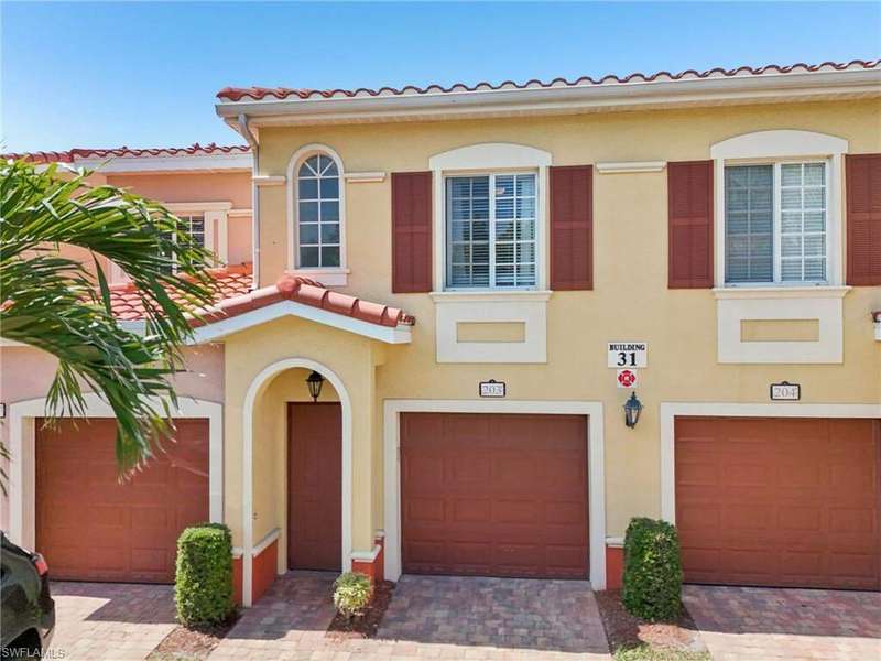 View of front of home featuring driveway, stucco siding, a tile roof, and an attached garage
