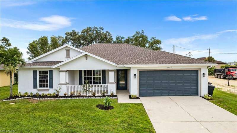 New landscaping and new exterior pant and carriage lights.Single story home with a front yard and a garage.