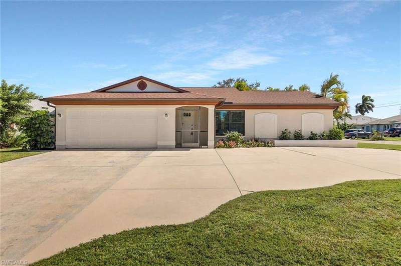 Front of home with large U shaped driveway and screened front entry.