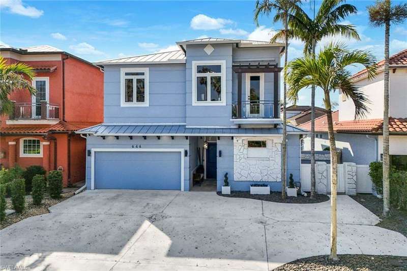 View of front of house featuring a garage and a balcony