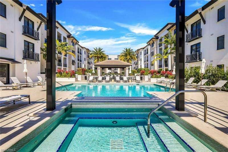 View of swimming pool featuring spa
