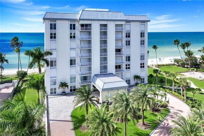 View of apartment building / complex with view of water and beach