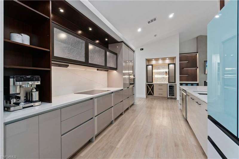 Kitchen featuring open shelves, modern cabinets, freestanding refrigerator, light wood-style flooring, and vaulted ceiling