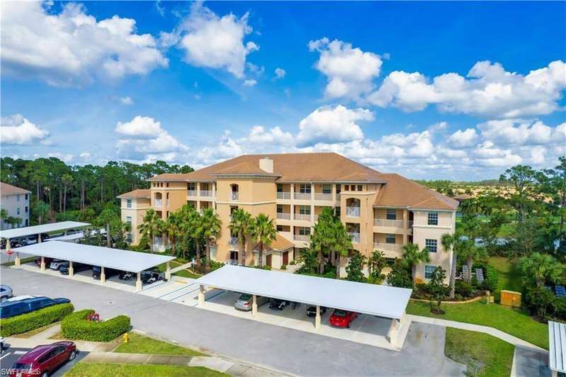View of property featuring covered and uncovered parking
