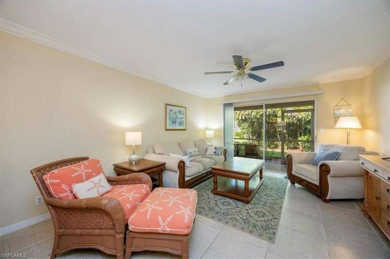 Living room featuring ornamental molding, light tile patterned floors, and ceiling fan