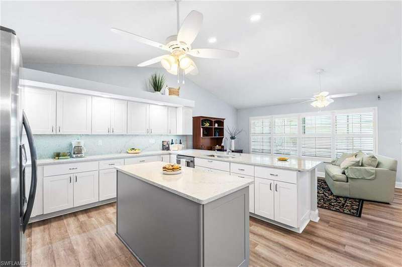 Kitchen featuring a peninsula, light wood-style floors, white cabinets, and stainless steel appliances