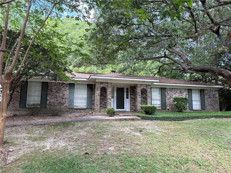 Ranch-style home featuring brick siding and a front lawn