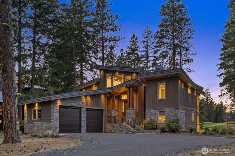 Twilight photo of Contemporary architecture with timeless appeal. The striking stone-and-concrete entry welcomes you home.