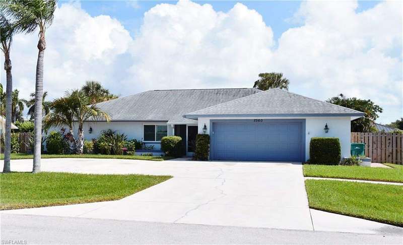 Ranch-style home featuring a garage and a front lawn