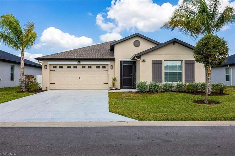 Ranch-style house with a garage and a front lawn