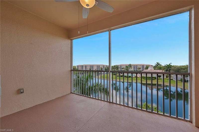 Balcony featuring a sunroom, a ceiling fan, and a water view