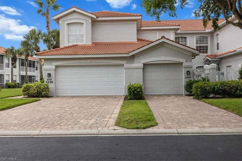 Mediterranean / spanish home featuring decorative driveway, an attached garage, a tiled roof, and stucco siding
