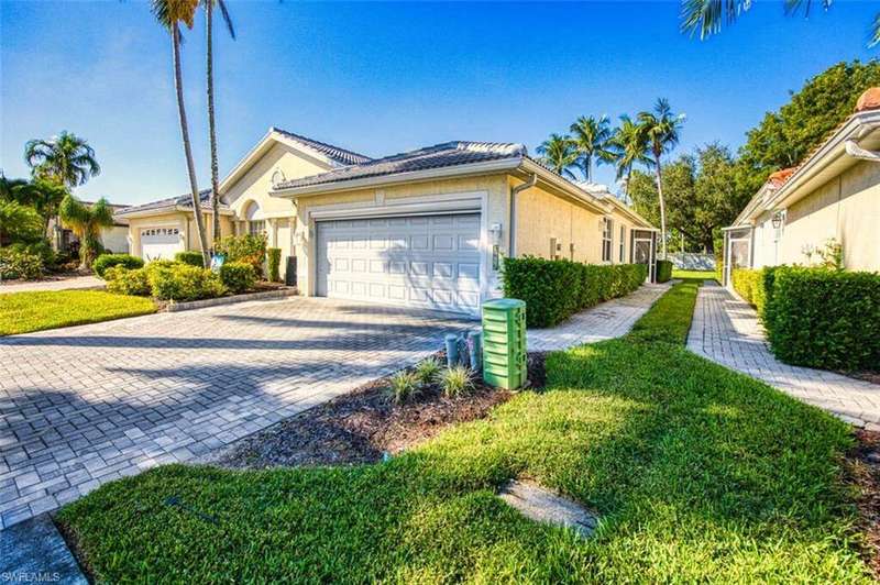 View of home's exterior featuring stucco siding, decorative driveway, a garage, and a lawn