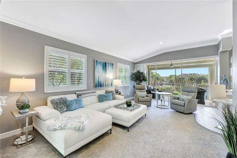 Living room with carpet floors, vaulted ceiling, and crown molding