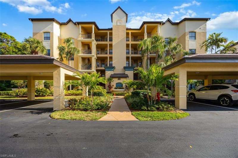 View of apartment building / complex with covered parking