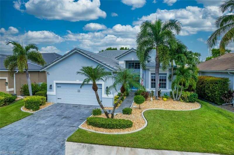 View of front of property with a garage and a front lawn