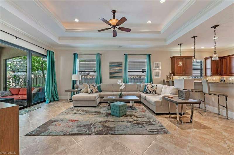 Great Room room featuring crown molding, a raised ceiling, and porcelain tiled flooring