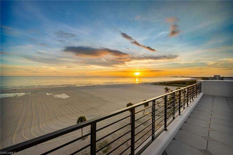 Balcony featuring view of water and beach